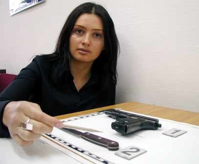 St. post. Małgorzata Taciuch - Kurasiewicz z KMP w Przemyślu prezentuje nóż i pistolet, który posługiwał się napastnik.