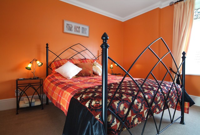 Sypialnia ze ścianami w kolorze pomarańczowymMalowanie wnętrz: kolorowe metamofozy ścian