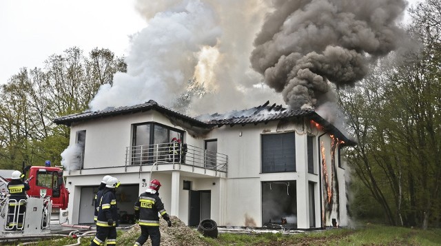 Do pożaru doszło w czwartek 27 kwietnia w Ochli, dzielnicy Zielonej Góry. Płomienie gasiło pięć jednostek zawodowej i ochotniczej straży pożarnej. Dom niestety spłonął, nie nadaje się do zamieszkania.  Pożar wybuchł w czwartek, 27 kwietnia około godz. 8:00. Kobieta, która była w domu, zdążyła zabrać dzieci i uciec na zewnątrz. Na miejsce szybko przyjechały zaalarmowane jednostki straży pożarnej zawodowej oraz wozy ochotników. – Pożar szybko się rozprzestrzeniał ze względu na duże, otwarte przestrzenie wewnątrz domu – mówi mł. bryg. Ryszard Gura, rzecznik zielonogórskich strażaków.Przed godz. 9:00 płomienie widać było na dachu i ścianach domu. Strażacy gasili dom z kilku stron jednocześnie. Część zespołu operowała wewnątrz budynku. W pewnym momencie dach zwalił się do środka obiektu. Runęły również kawałki ścian luksusowego domu.- W tej chwili ciężko mówić o przyczynie pożaru, ustali to policyjne dochodzenie – mówi mł. bryg. Gura. Możliwe, że doszło do zwarcia instalacji elektrycznej w nowym domu. Przeczytaj też:  Pożar bloku w Zielonej Górze. Trzy osoby ciężko ranne. Około 100 osób ewakuowano [ZDJĘCIA]