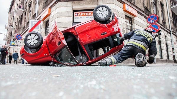 W wyniku wypadku czerwony fiat panda wylądował na dachu.