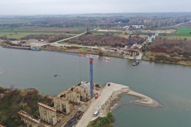 Na obu brzegach Wisły powstają potężne betonowe filary. Przy samym nurcie rozpoczynają się prace przy tworzeniu przęseł