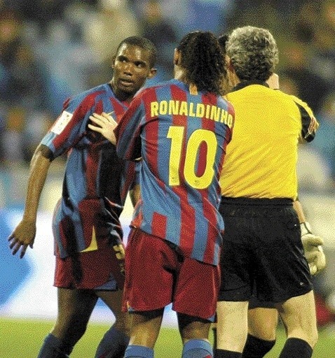 Samuel Eto`o (z lewej) powstrzymywany przez Ronaldinho i arbitra.