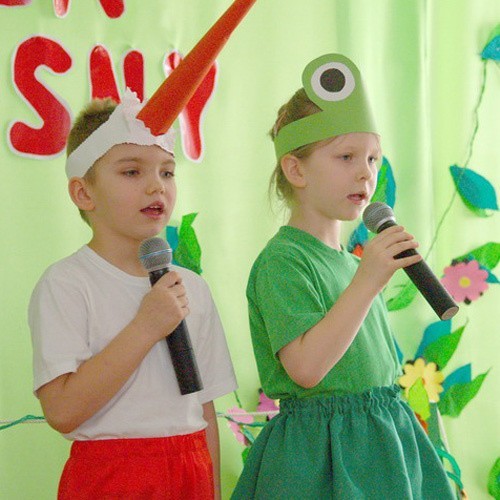 Przedszkolaki przebrane za bociana i żabkę śpiewają piosenkę o wiośnie.
