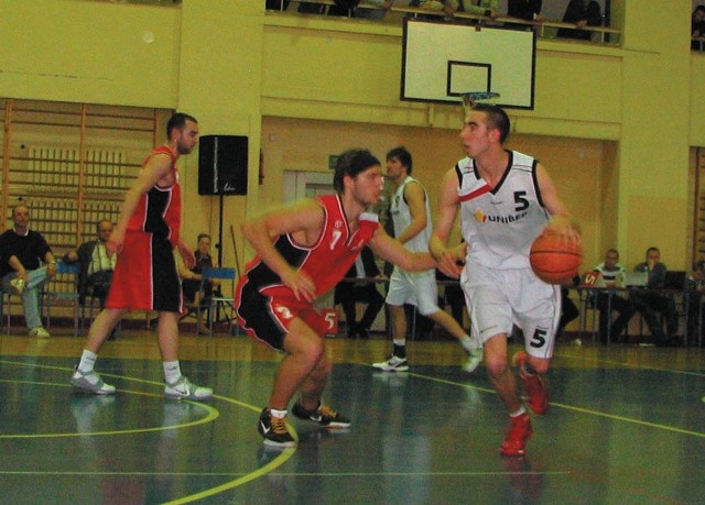 Młody bielszczanin Aaron Weres (nr 5) mija Mateusza Biega (nr 7) z zespołu Basketu Kwidzyn.