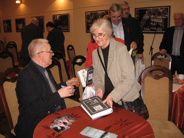 Profesor Marian Drozdowski podpisuje swoją ksiażkę Elżbiecie Maj, znanej w Radomiu architektce.