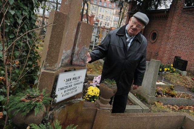 Janusz Galap przy zniszczonym grobie swojego dziadka pochowanego na cmentarzu Starofarnym
