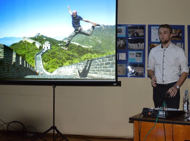 Kuba Rydkodym na spotkaniu z fanami podróży, pokazuje zdjęcie z Chin przy Wielkim Murze.