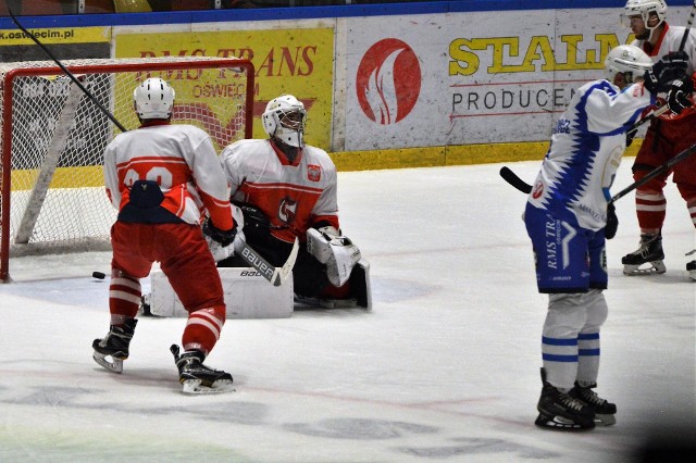 Wojciech Wojtarowicz (w białej koszulce) po zmianie lotu krążka zdobył trzecią bramkę dla Unii Oświęcim, która w meczu hokejowej ekstraklasy ostatecznie pokonała Kadrę PZHL U23 4:0.