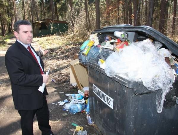 Piotr Dziedzic pokazuje miejsce, gdzie właściciel samochodu porzucił worek ze śmieciami.