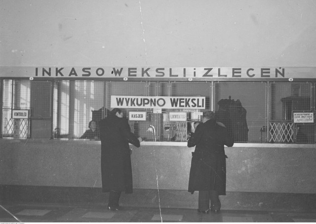 Interesanci przed okienkami pocztowymi na Poczcie Głównej w Krakowie.