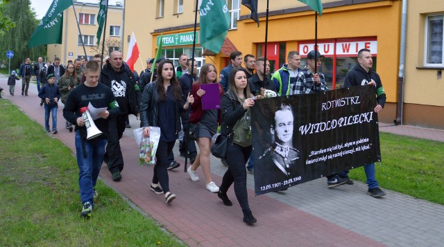 Członkowie Marszu Pileckiego idą chodnikiem przez Stalową Wolę, wykrzykując: „Cześć i chwała bohaterom”, „Wielka Polska narodowa”, „My rotmistrza pamiętamy, komunistom żyć nie damy”