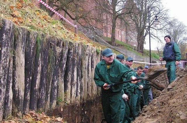 Prace przy rozbiórce drewnianej palisady.