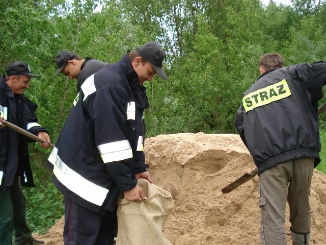 Strażacy z Ochotniczej Straży Pożarnej w Pawłowicach i jednostki w Lipsku napełniają worki z piaskiem by chronić Kępę Piotrawińską, która może być zalana.  