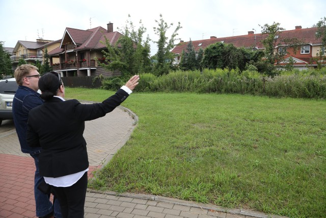 Elżbieta Kauc-Dmochowska pokazuje miejsce, gdzie widziałaby kapliczkę. Jej dom widać po lewej. - Jeśli ziemię kupi deweloper i wykopie podziemne garaże, moja piwnica będzie stale zalewana, popękają mi ściany  - mówi.