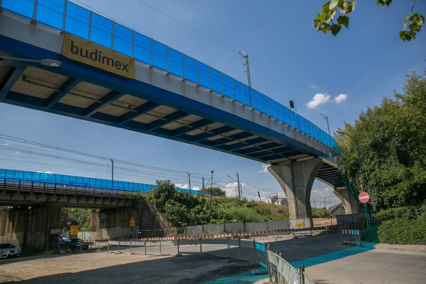 Niebieskie ekrany akustyczne wzdłuż estakady kolejowej są...