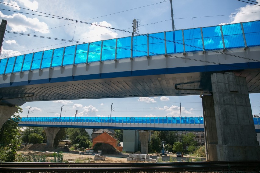Niebieskie ekrany akustyczne wzdłuż estakady kolejowej są...