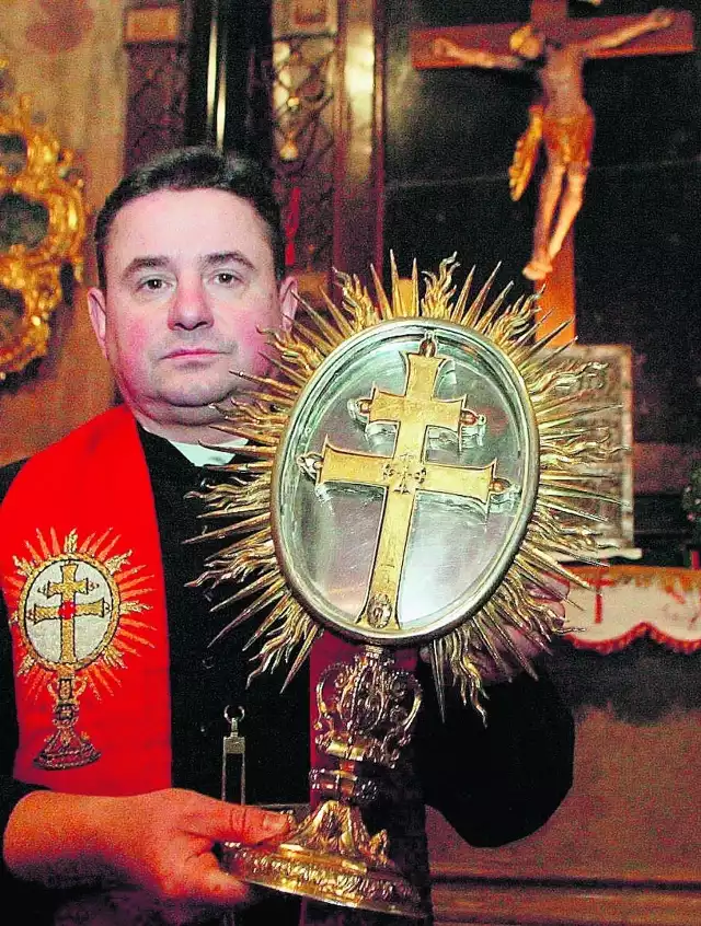 Ojciec superior Bernard Briks prezentuje relikwiarz z drzazgami z krzyża, który można znaleźć  na Świętym Krzyżu