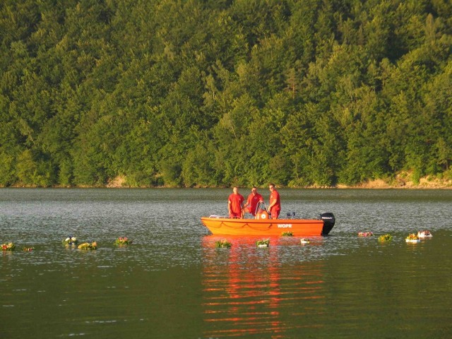 Ratownicy WOPR puszczają wianki na wodę.