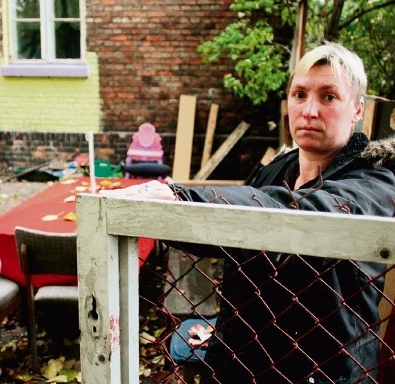 Monika Domagalska przed zrujnowanym domem