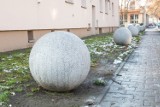 Tajemnicze betonowe kule przy blokach w Poznaniu. Budzą zdziwienie mieszkańców. Dlaczego się tam znalazły? 
