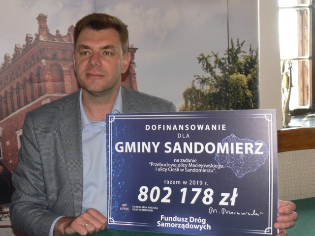 Marcin Marzec, burmistrz Sandomierza pokazuje wysokość dofinansowania do remontu ulicy Cieśli i Maciejowskiego.
