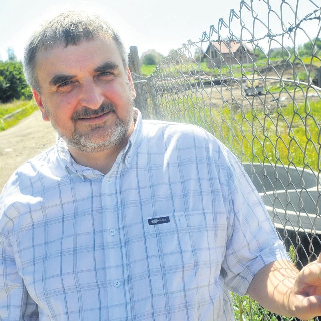 Stefan Płażek, jeden z protestujących mieszkańców, obok terenu kontrowersyjnej budowy