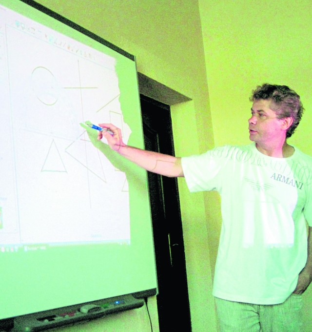 Matematyk Tomasz Grębski przy multimedialnej tablicy