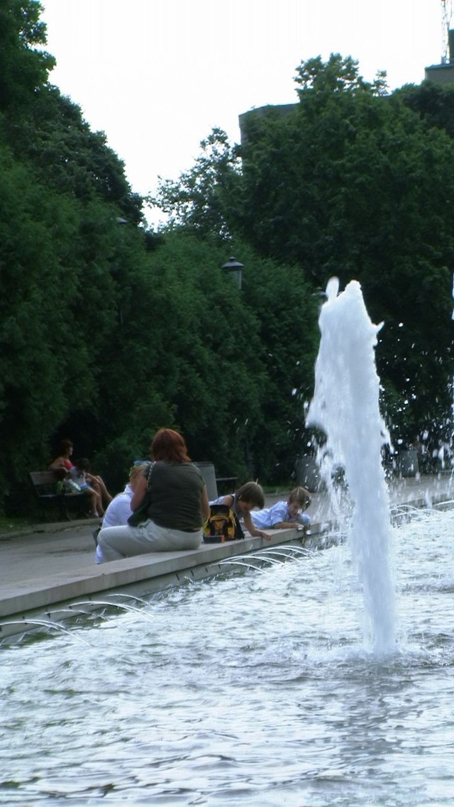 Dzieci moczą ręce w parku Rydza-Śmigłego.
