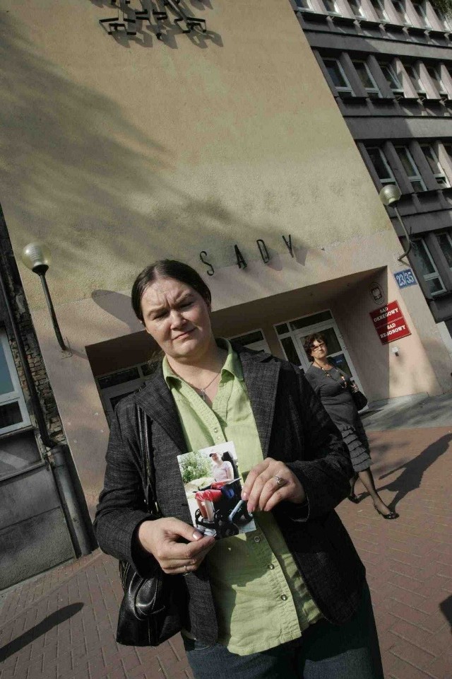 Małgorzata Marchewka ze zdjęciem córki przed wejściem do sądu