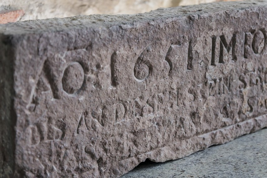 Awers bloku kamienia z historyczną inskrypcją, którą można...