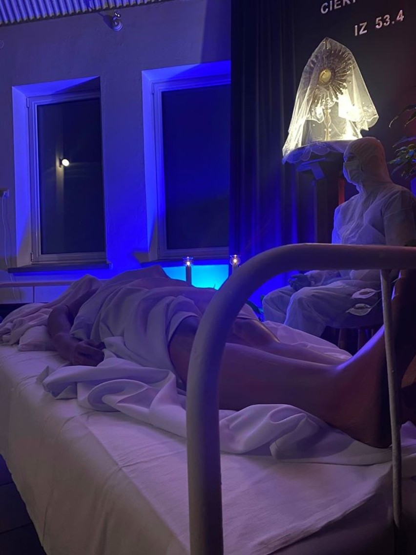 Grób Pański w czasie koronawirusa: szpitalne łóżko z medykiem w masce i kombinezonie
