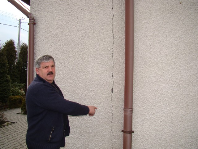 Andrzej Kociszewski, mieszkaniec Brzezinki, pokazuje pęknięcia na swoim domu