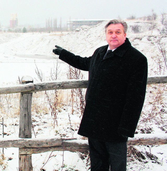 Burmistrz Stanisław Szczurek pokazuje miejsce, skąd na  wyrobisko ciągle dopływa woda wypłukując z gleby odpady