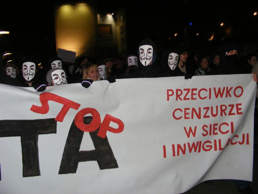 Protestujący na ul.Półwiejskiej z wielkim transparentem