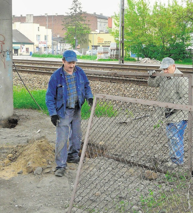 Pracownicy PKP podczas naprawy płotu