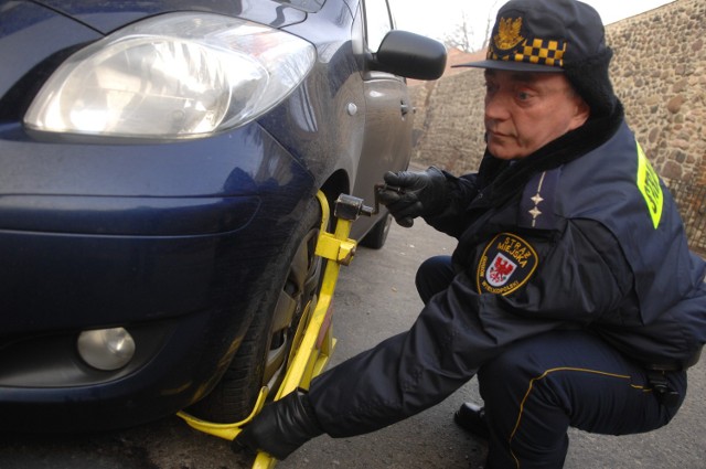 Inspektor Leszek Bukowski wczoraj montował blokadę na kole samochodu zaparkowanego wbrew przepisom przy ul. Zabytkowej. Przyznaje, że kiedyś kierowcy parkowali tu na zakazie niemal non stop. Teraz takich aut jest mniej.