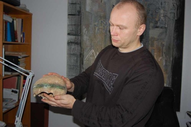 Archeolog Kamil Kajkowski pokazuje czaszkę z diademem