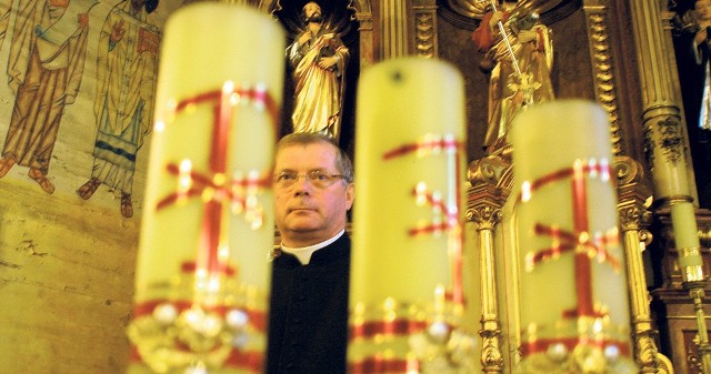 Ks. Andrzej Loranc w środku drewnianego kościółka