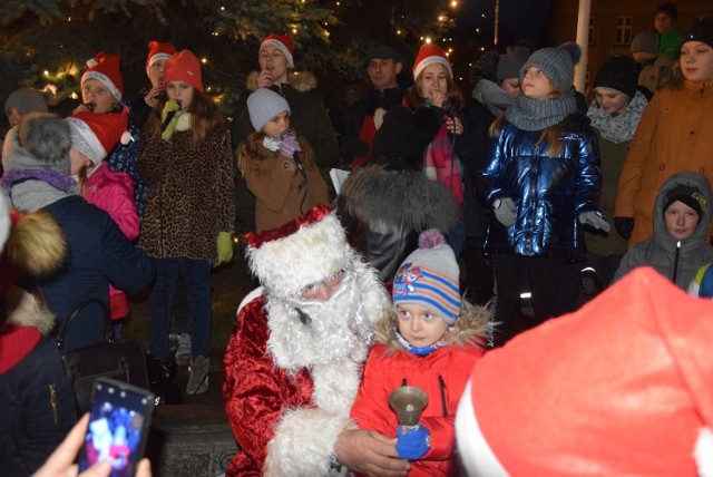 Mikołaj chętnie pozował do zdjęć i rozdawał dzieciom słodycze. Towarzyszyły mu Śnieżynki (w tle)