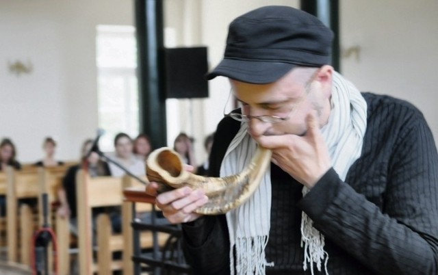 Reżyser Paweł Passini grający na shofarze - tradycyjnym żydowskim instrumencie