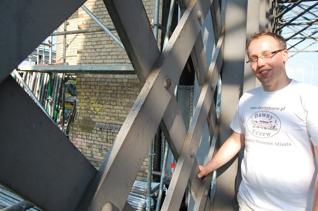Łukasz Brządkowski pokazuje napisy na wieżyczkach mostu