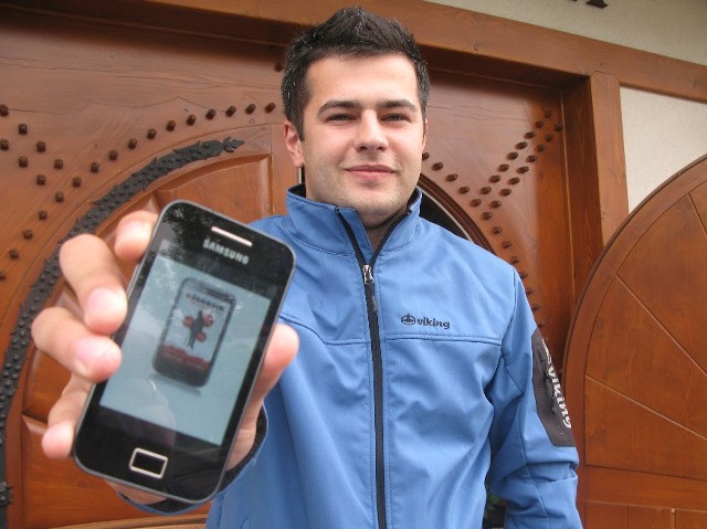 Łukasz Dorula z dumą prezentuje swoje najnowsze dzieło - przewodnik turystyczny na telefon