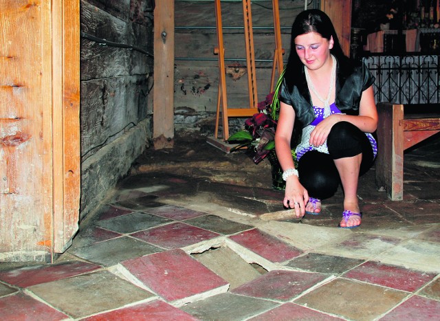 Przewodniczka Małgorzata Nalepa pokazuje podmytą podłogę w nawie zabytkowego kościoła w Binarowej