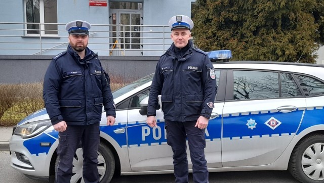 Policjanci Piotr Bucki i Maciej Cygan przy swoim radiowozie. To oni, wracając do domu po służbie, ocalili życie młodego mężczyzny.