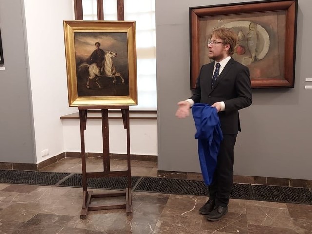 Doktor Mikołaj Getka-Kenig, dyrektor Muzeum Zamkowego w Sandomierzu prezentuje jeden z nabytków - obraz „Jeździec na siwym koniu” Piotra Michałowskiego.