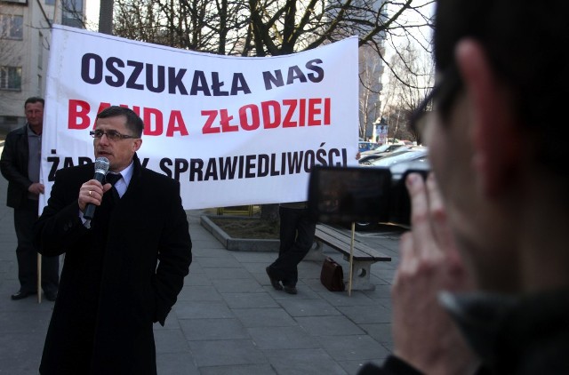 Wiceprzewodniczący rady gminy Chełmiec na tle transparentu, który oburzył przedsiębiorcę