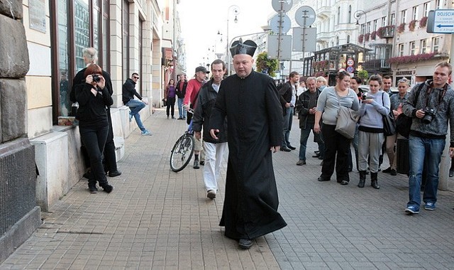 Hajncel ubrany w sutannę zasiadł we wtorek po południu na krześle na ulicy Piotrkowskiej naprzeciwko Saspolu. Na ziemi położył aksamitną poduszkę, podwinął sutannę i obficie nałożył na swoje kolana bitą śmietanę. Potem zagłębił się w lekturze Pisma Świętego jednocześnie machając rózgą.