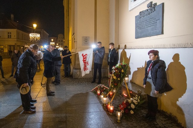 Uroczystość w 42. rocznicę wprowadzenia w Polsce stanu wojennego przed tablicą na kościele ojców jezuitów w Toruniu - o północy 13 grudnia