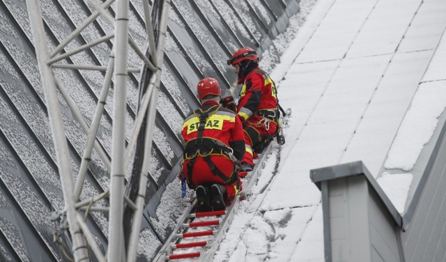 Strażacy zabezpieczają zerwane po wichurze pokrycie dachowe na Hali Podpromie w Rzeszowie.
