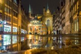 Światła nocnego Gdańska odbite w kałuży. Miasto po deszczu zachęca do wieczornych spacerów [zdjęcia]